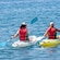 2 kayakers paddling in calm water